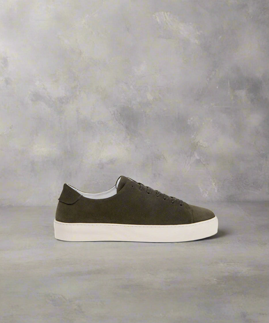 A dark khaki suede men's sneaker with a white sole and lace-up closure.