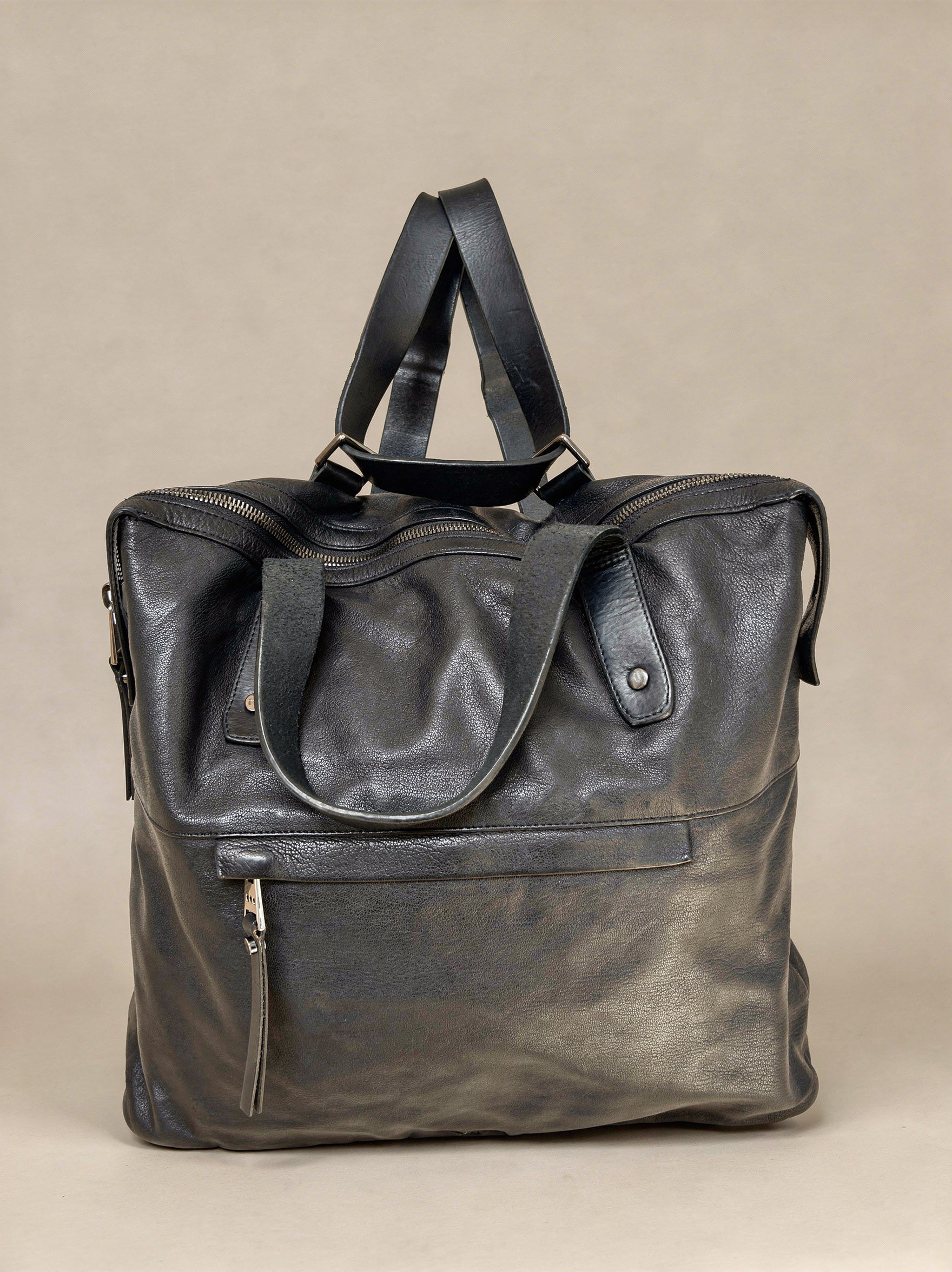 Black leather bag on a beige background