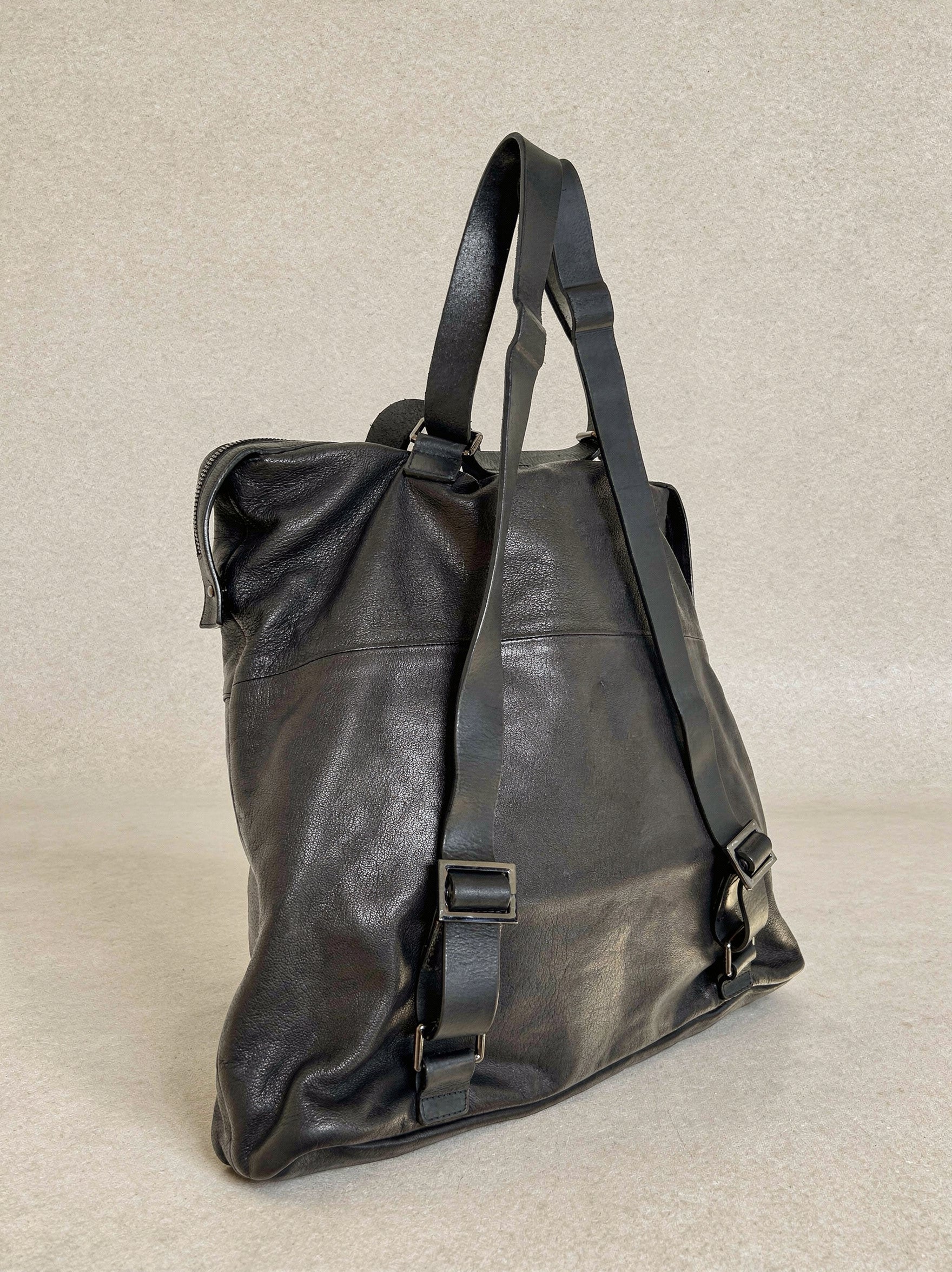 Black leather bag on a beige background