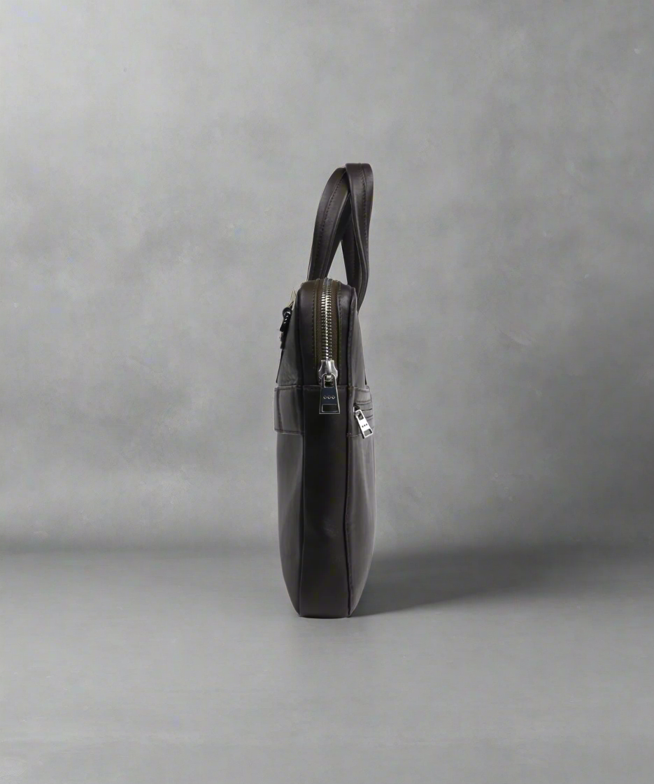 Brown Slim Royal RepubliQ leather briefcase on a gray background