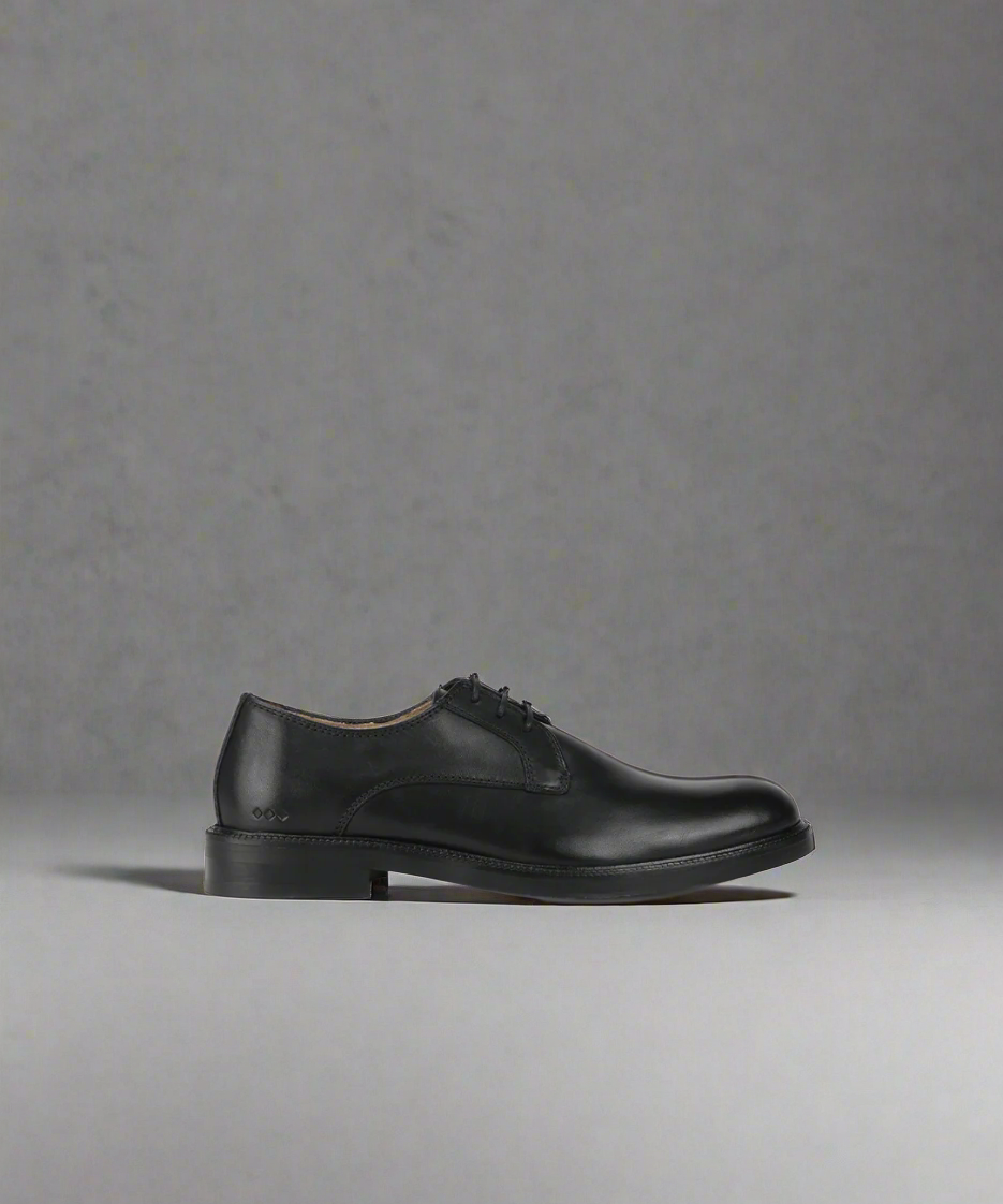 A black, leather derby shoe with a smooth finish and lace-up closure.