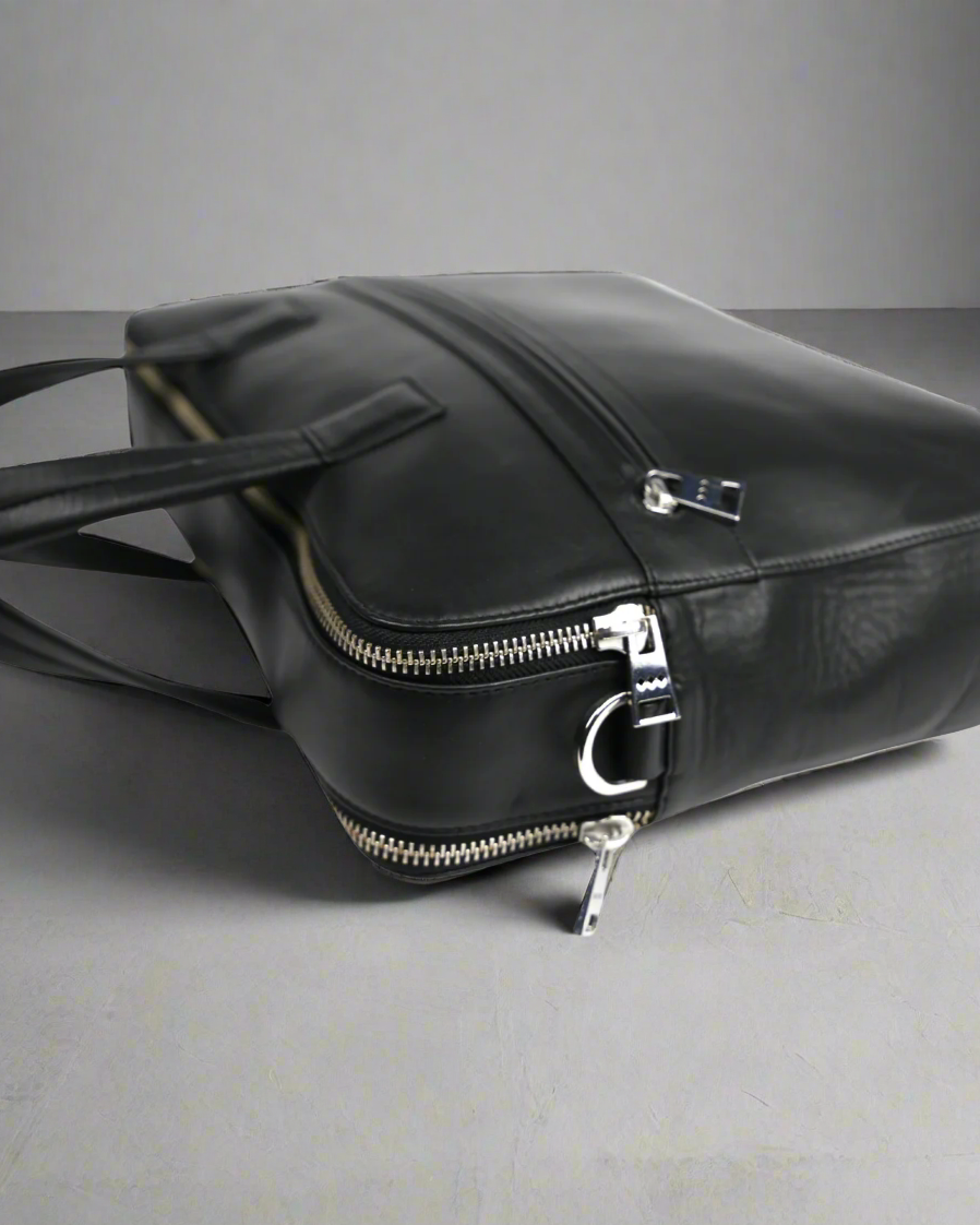 Black Royal RepubliQ leather bag with zippers on a gray background