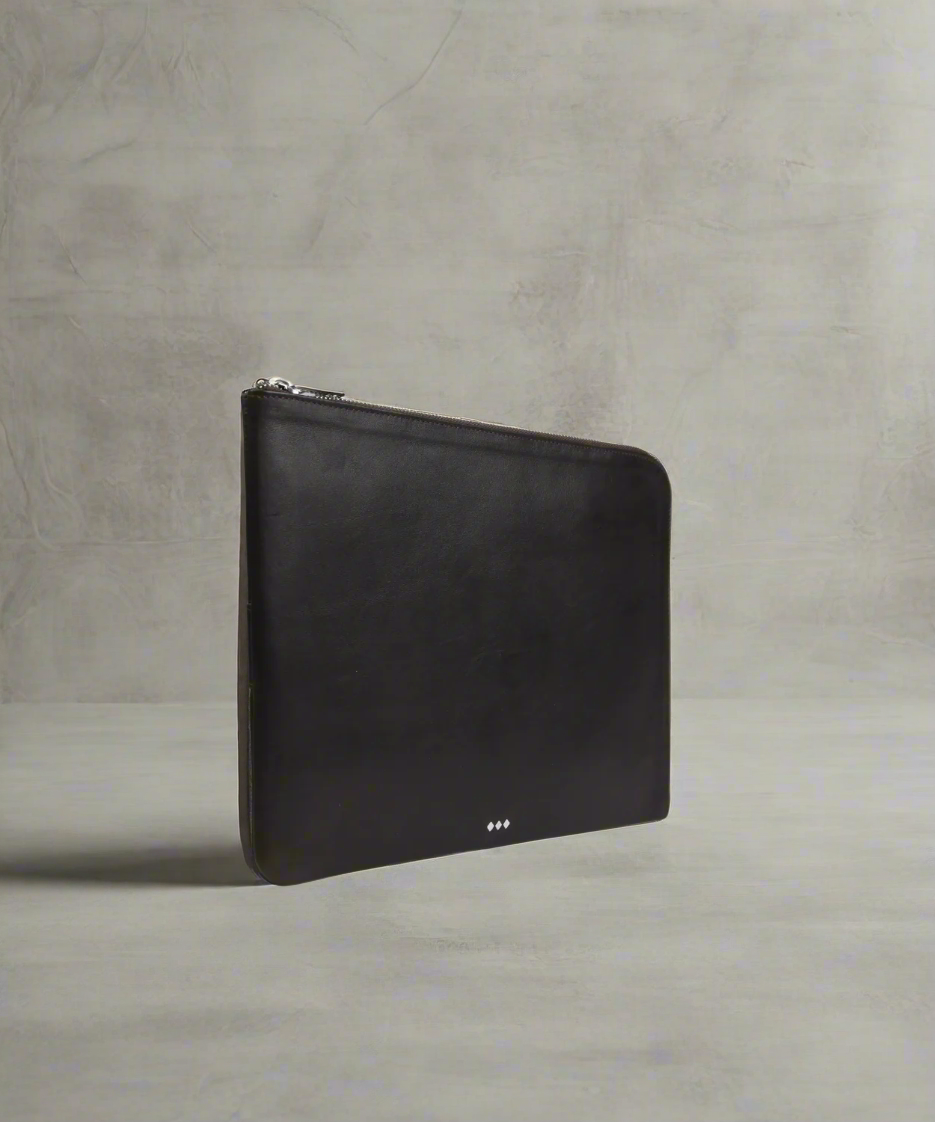 Black leather laptop sleeve 13" on a textured gray surface