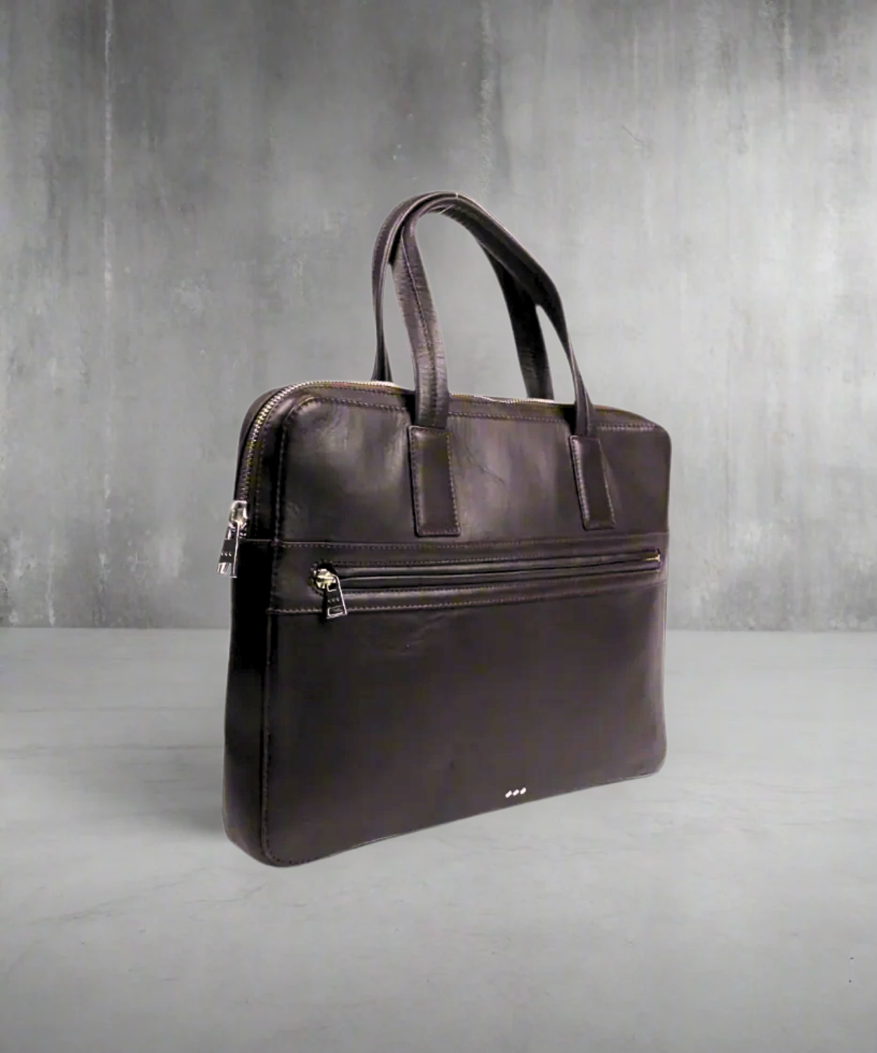 Brown Royal RepubliQ leather briefcase on a gray background