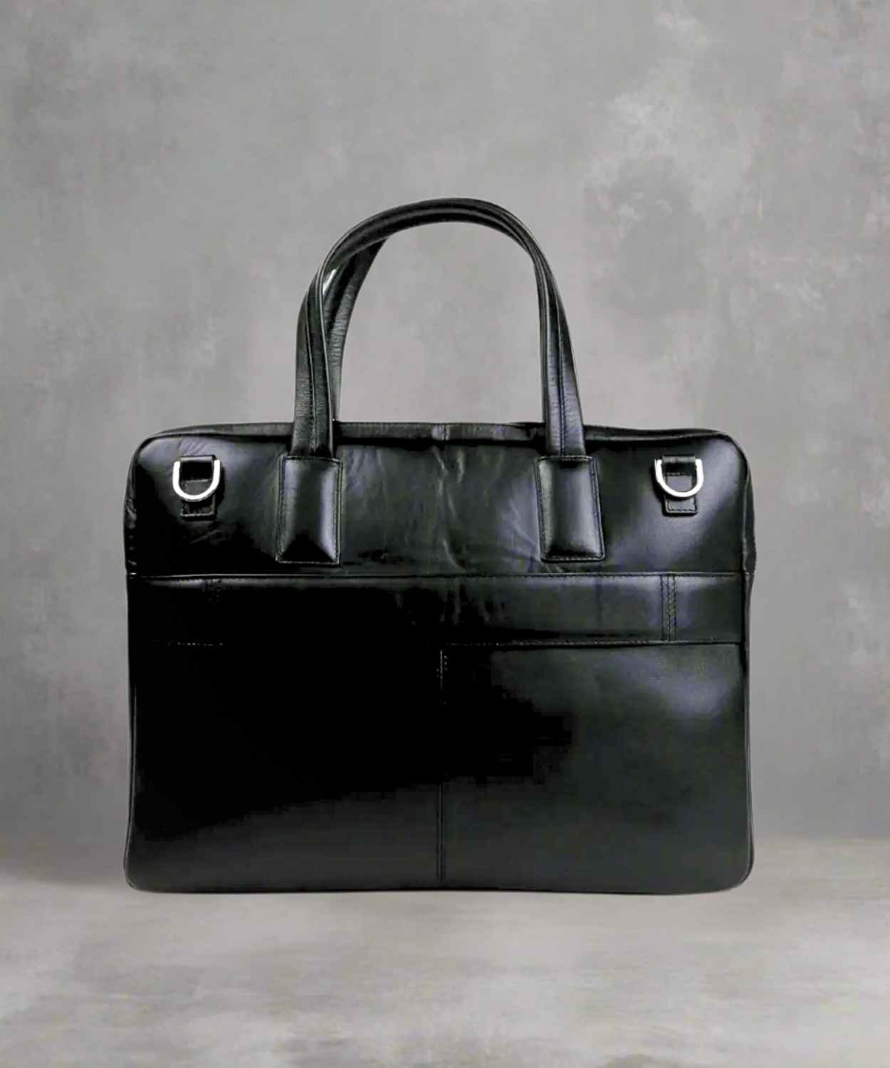 Black Royal RepubliQ leather briefcase on a gray background