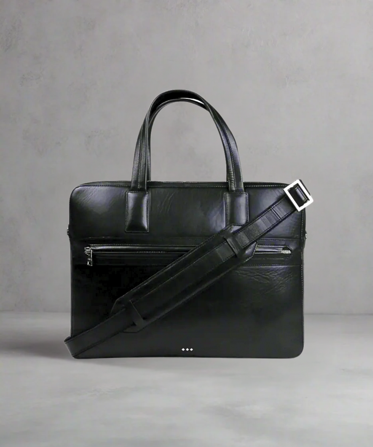 Black Royal RepubliQ leather briefcase with shoulder strap on a gray background