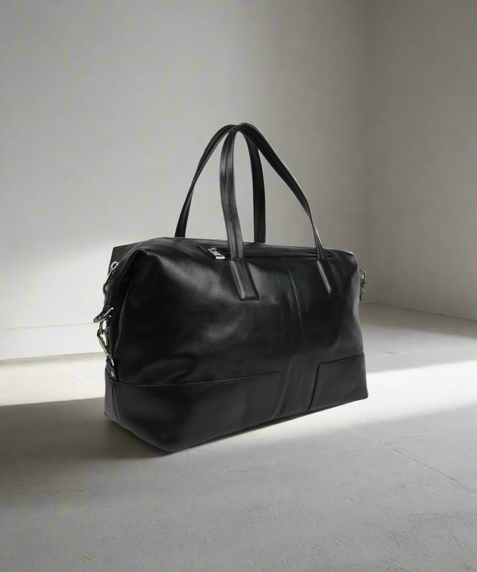 Black Royal RepubliQ leather bag on a light gray floor with a neutral background