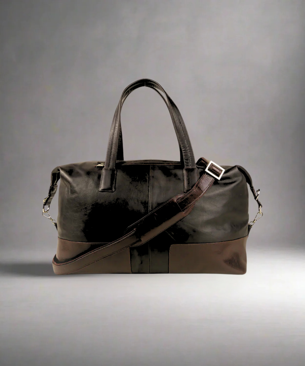 Brown Royal RepubliQ leather duffel bag with a shoulder strap on a gray background