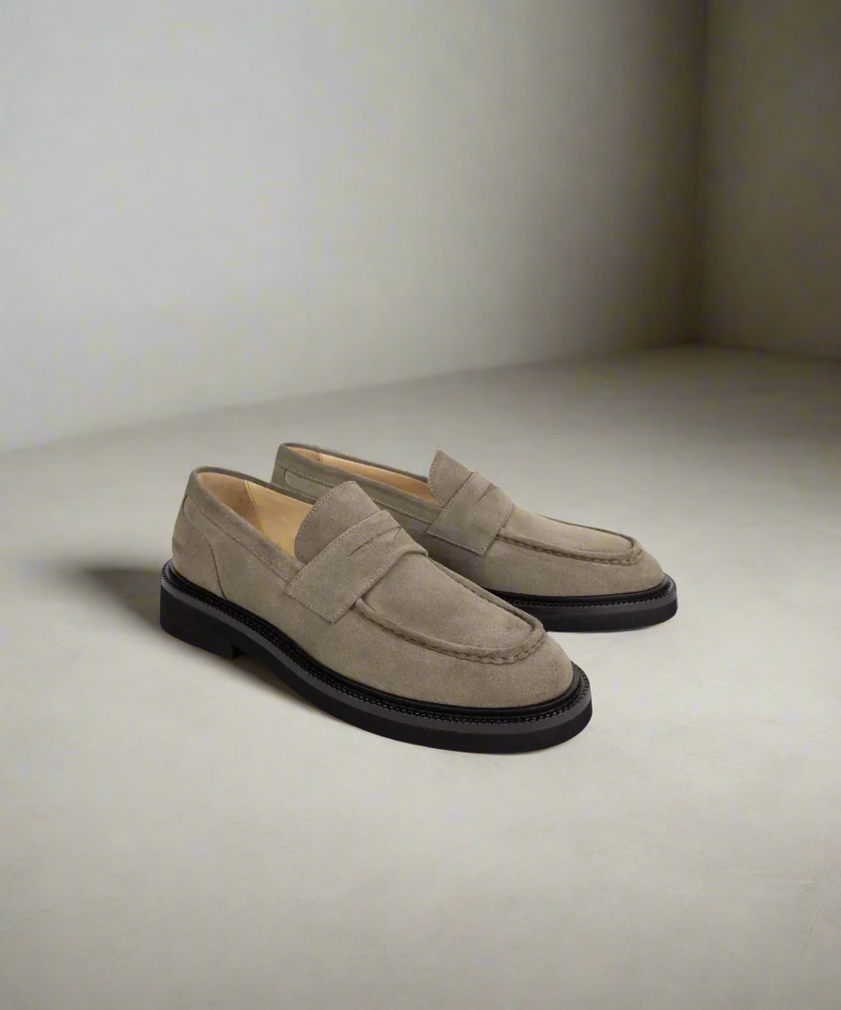 Pair of beige Royal RepubliQ loafers on a light gray background