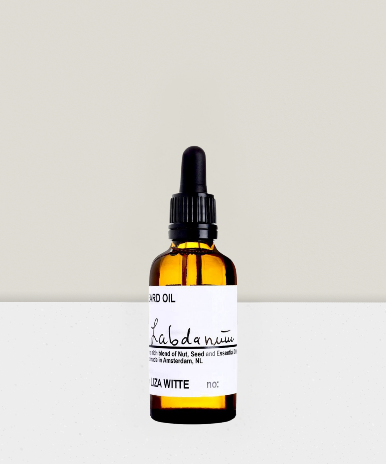 A bottle of Liza Witte beard oil with a dropper cap, labeled 'Labdanum', against a neutral background.