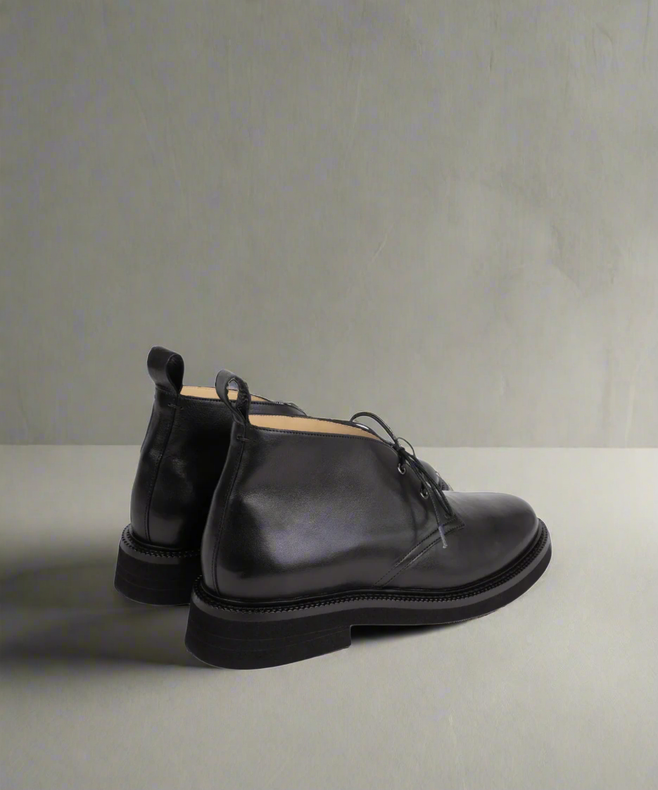 Pair of black leather shoes on a light gray background