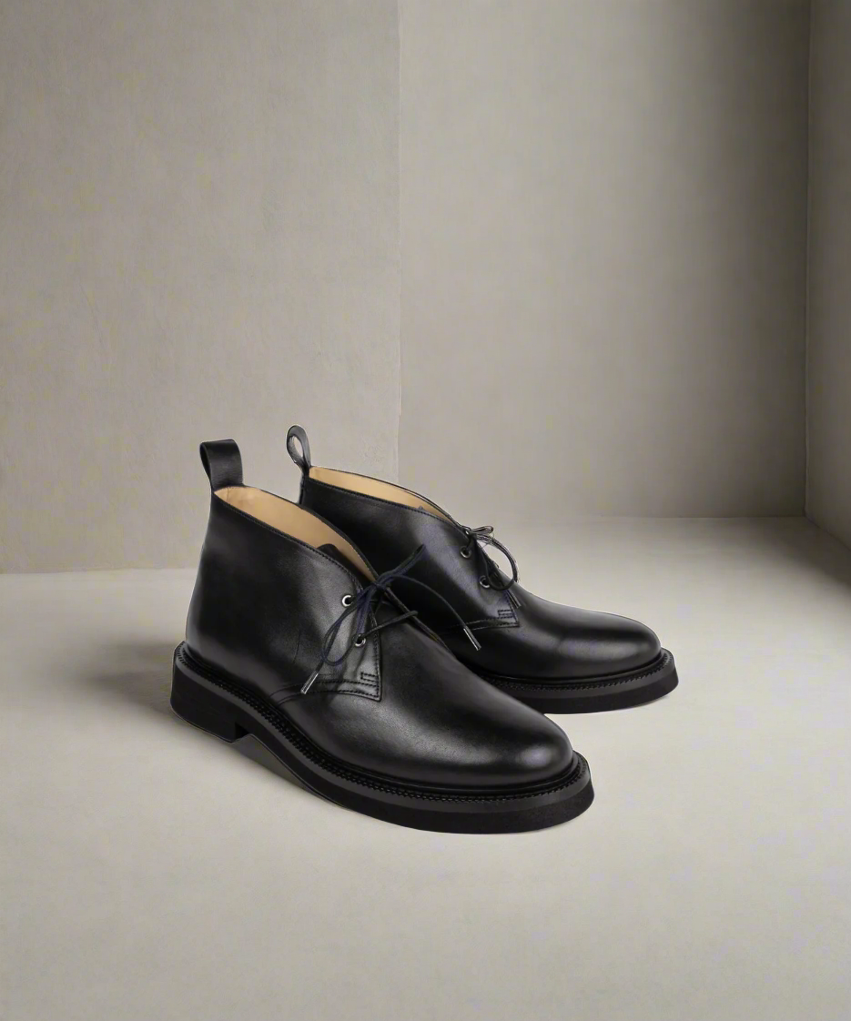 Pair of black leather shoes on a neutral background