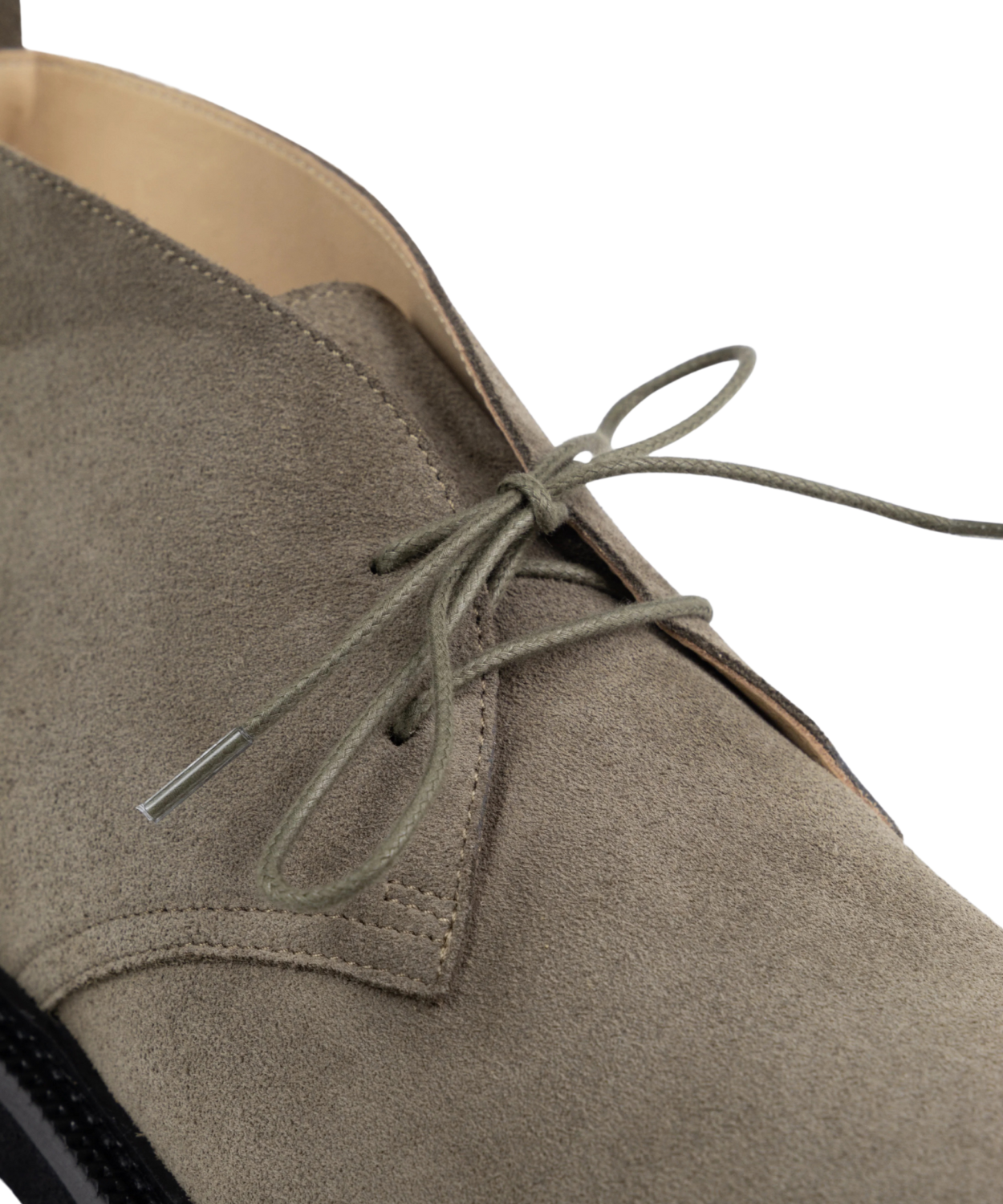 Close-up of a brown Royal RepubliQ suede chukka with laces on a white background