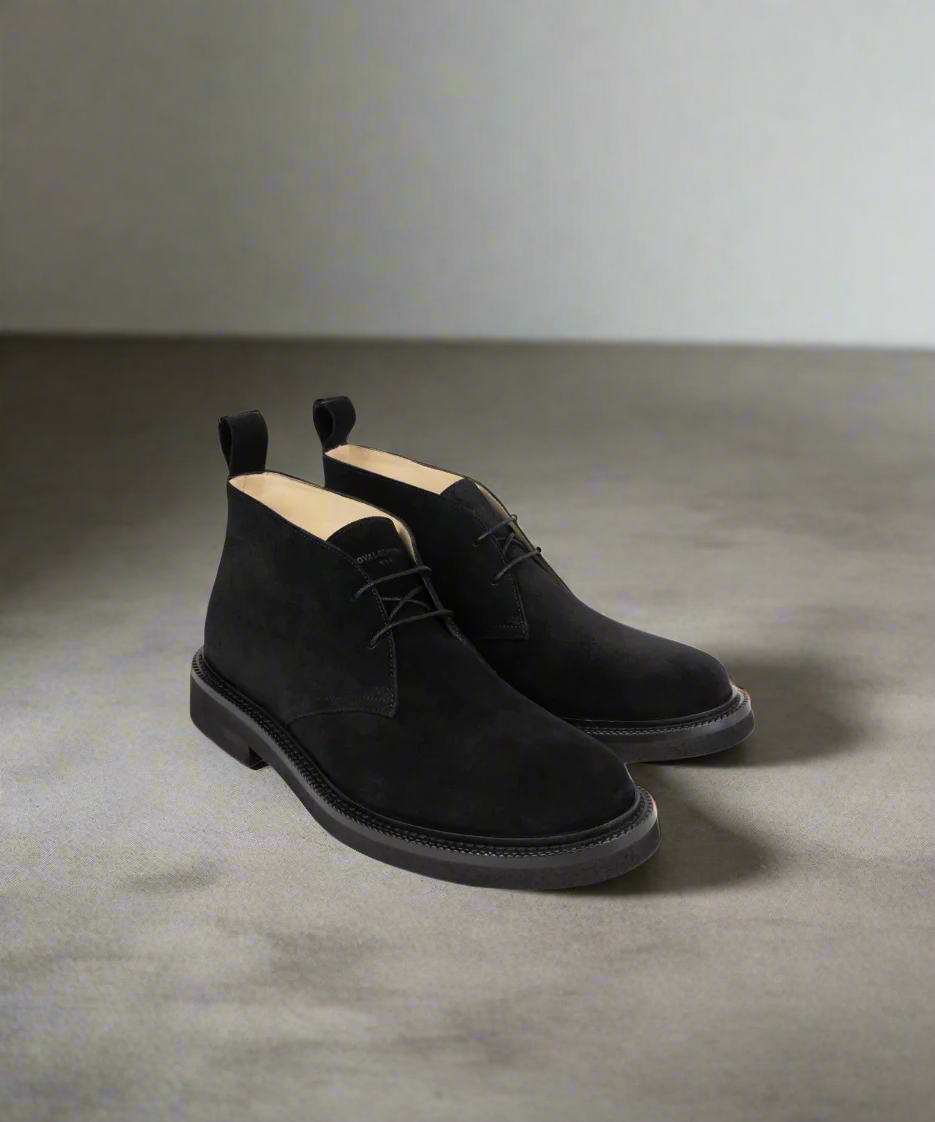 Pair of black suede shoes on a gray background