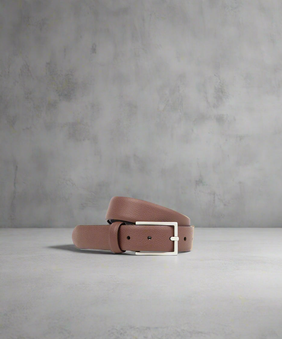 Brown Royal RepubliQ leather belt with a matt silver buckle on a gray background