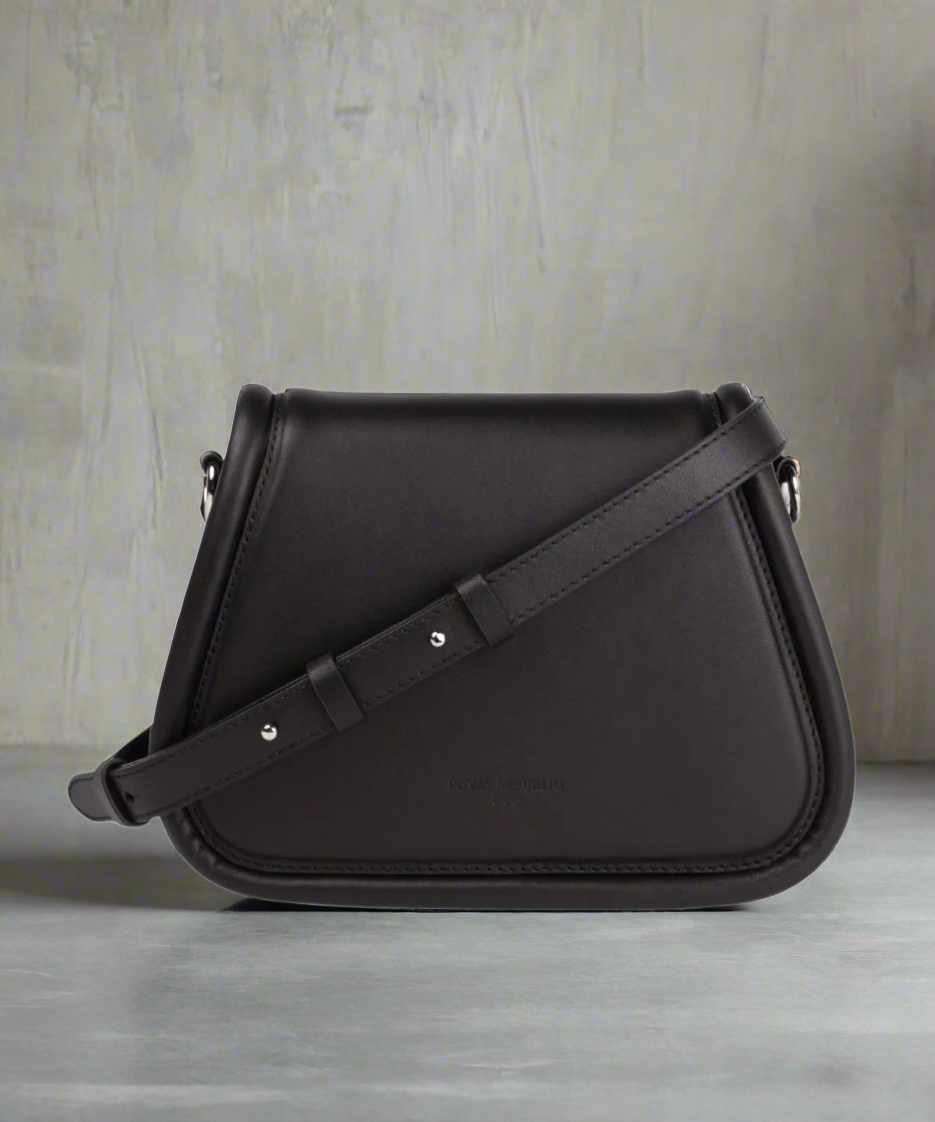 Black Royal RepubliQ saddle evening bag on a gray background