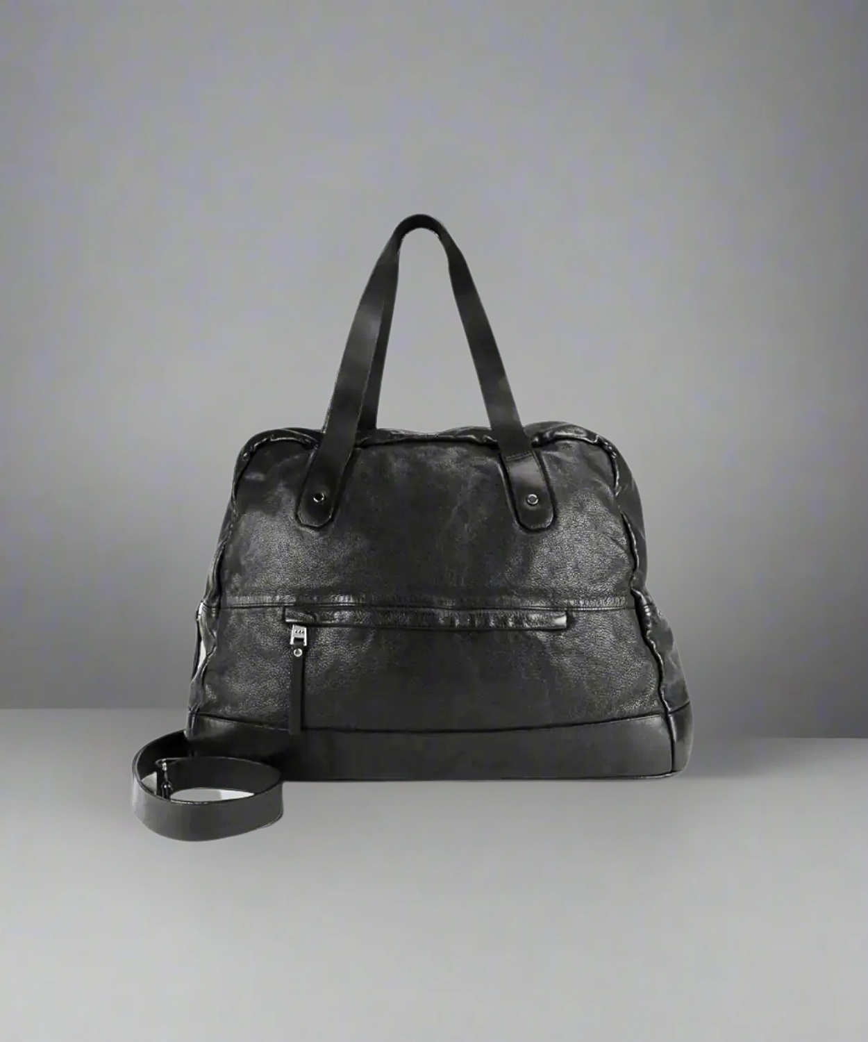 Black Royal RepubliQ washed leather weekend bag on a gray background.