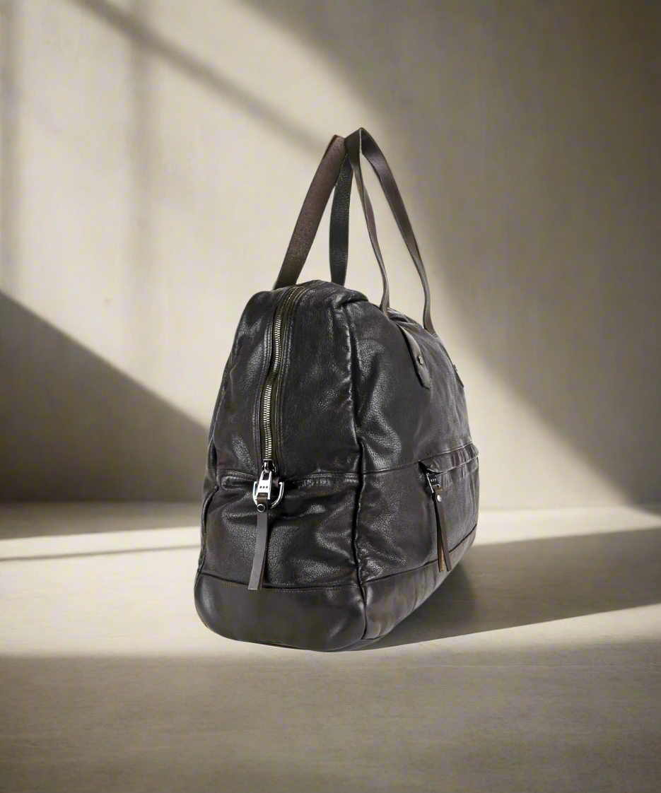 Dark brown Royal RepublQ washed leather weekend bag on a neutral background