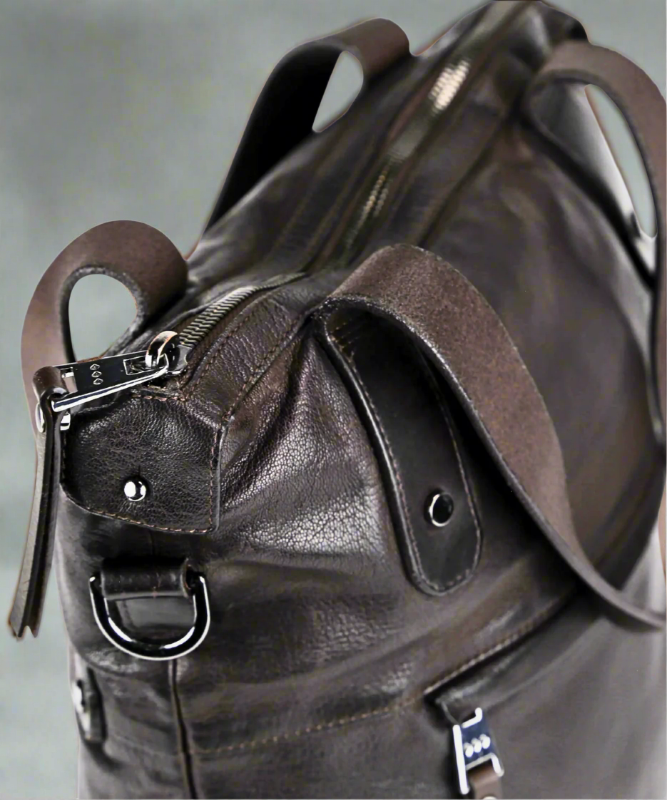 Close-up of a brown Royal RepubliQ washed leather tote with visible stitching and hardware.