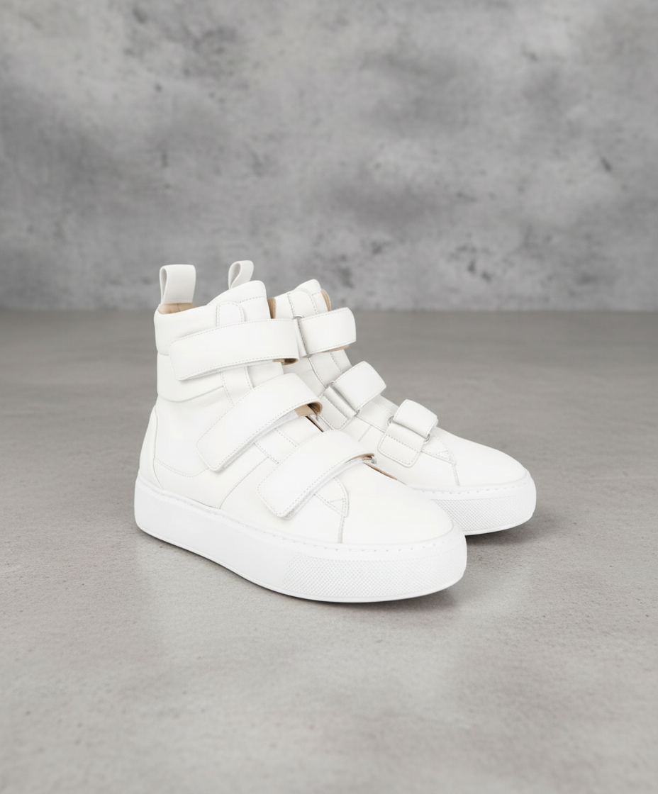 White Royal RepubliQ high-top sneakers with strap details on a gray background