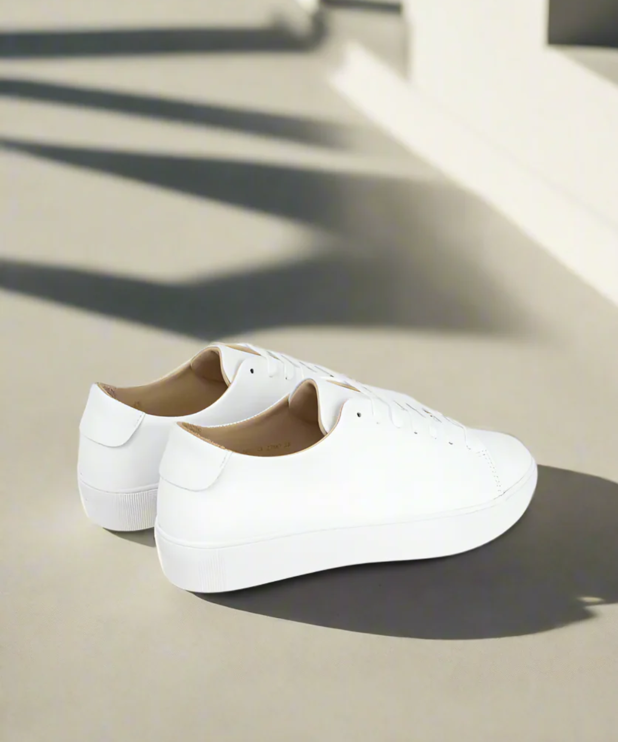 White Royal RepubliQ minimalistic sneakers on a light surface with shadows