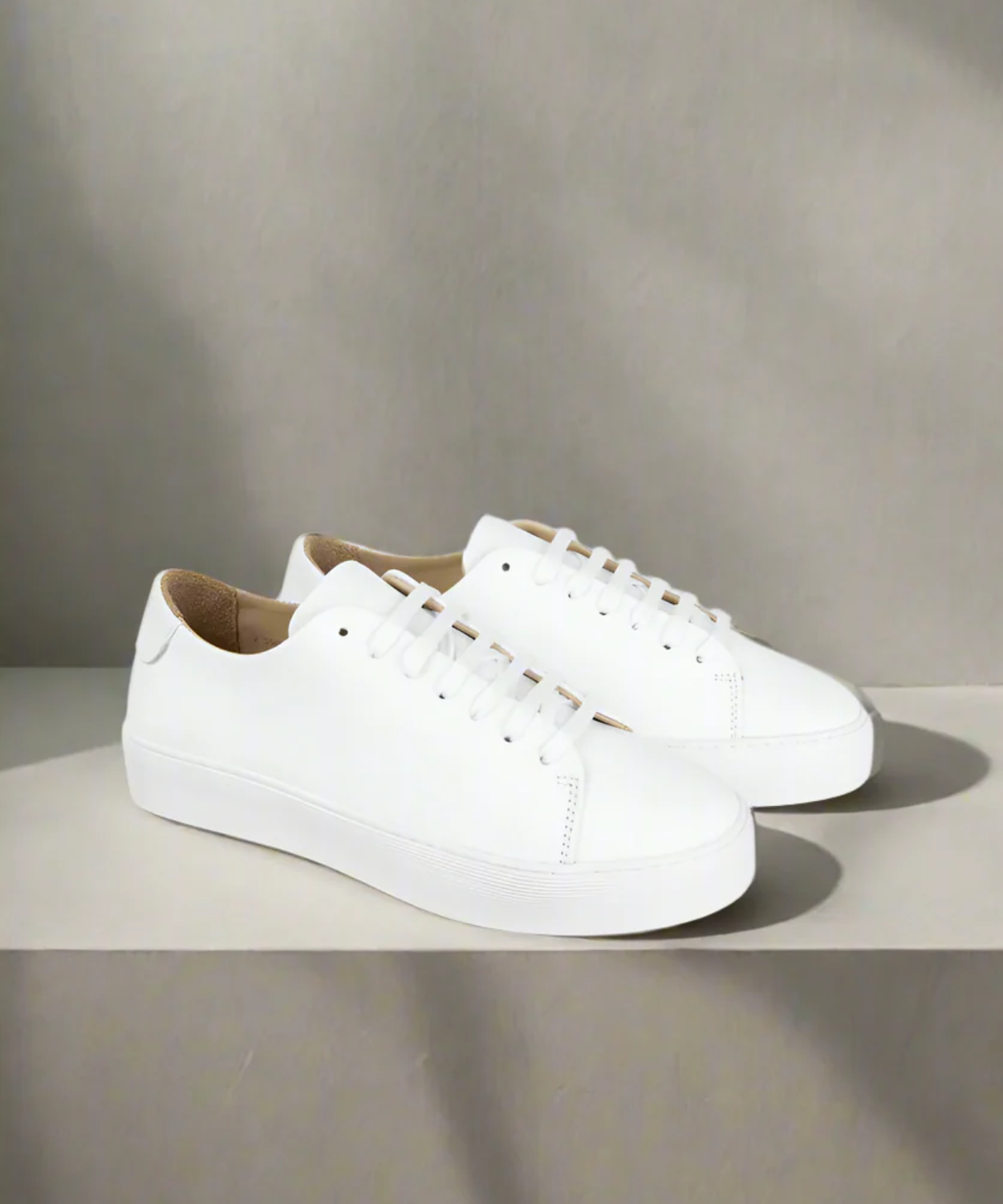 White Royal RepubliQ sneakers on a light gray surface with a neutral background