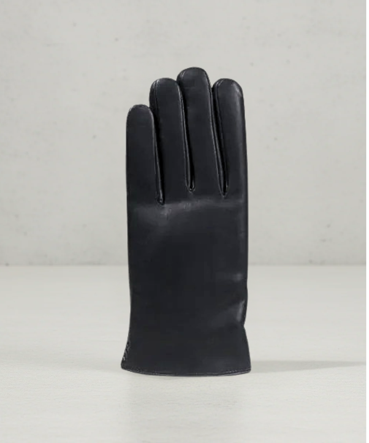 Black leather glove on a light gray background