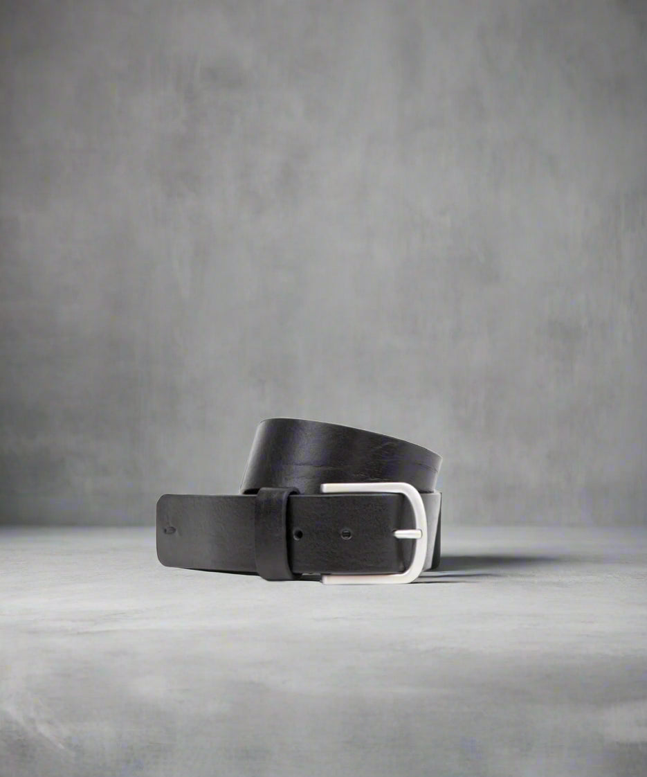 Black Royal RepubliQ leather belt with a matt silver buckle on a light gray background