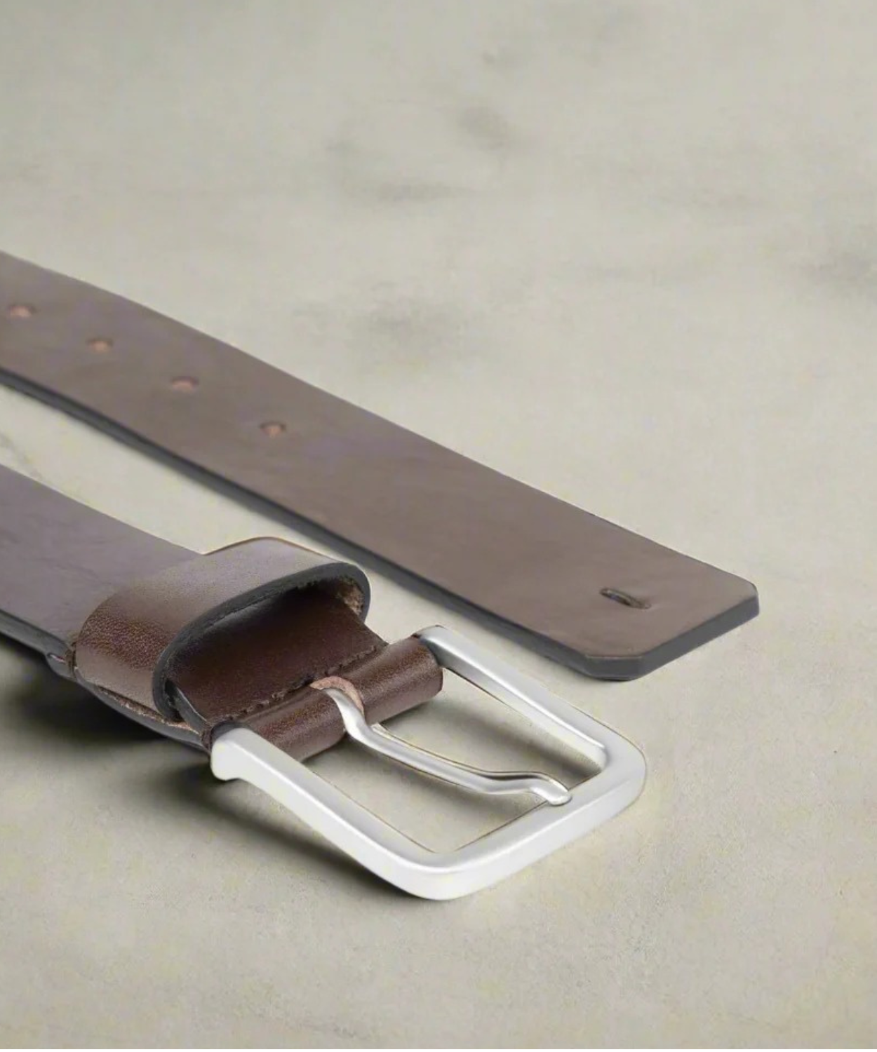 Brown Royal RepubliQ leather belt with silver buckle on a light gray background