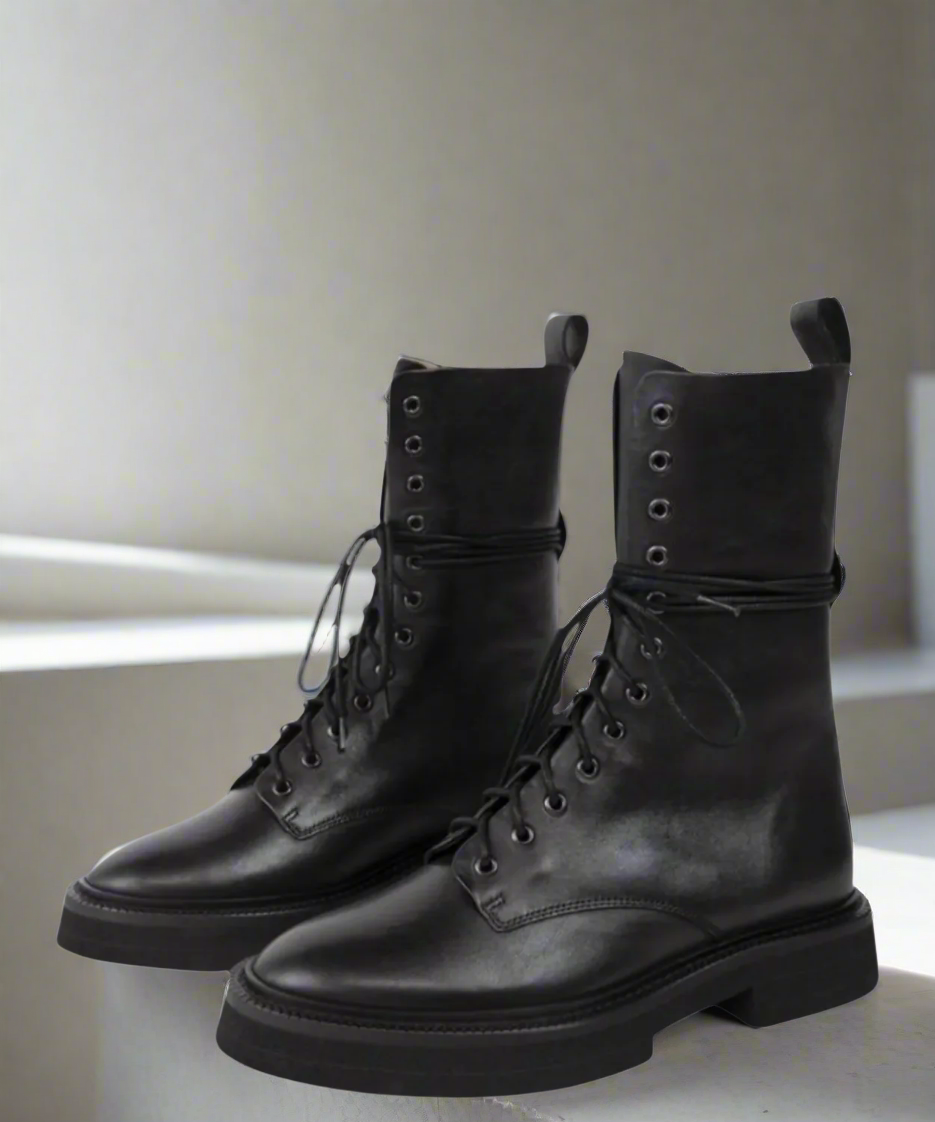 Pair of black leather boots on a light background