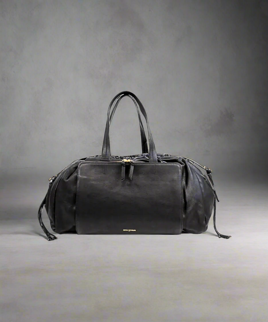 Black Royal RepubliQ leather duffel weekend bag for women on a gray background.