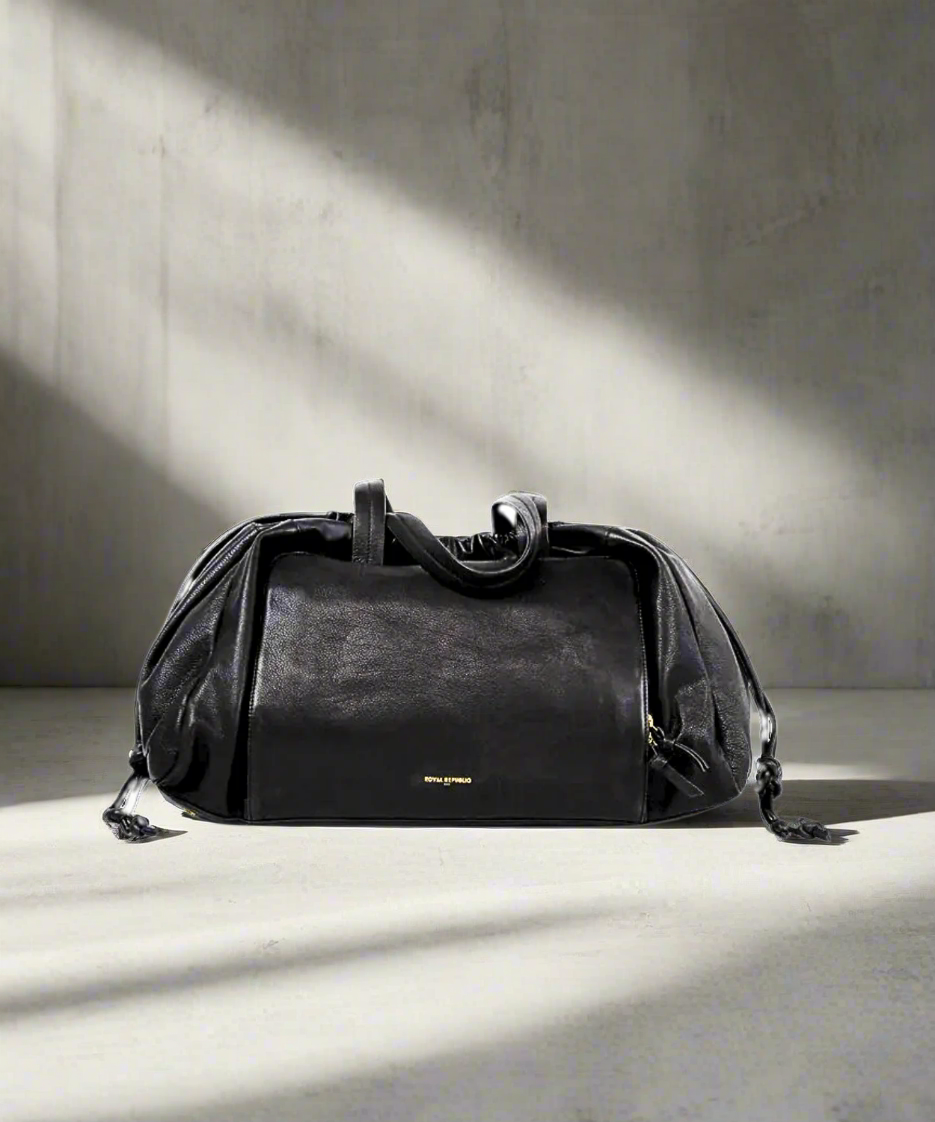 Black Royal RepubliQ leather duffel weekend bag for women on a gray background.