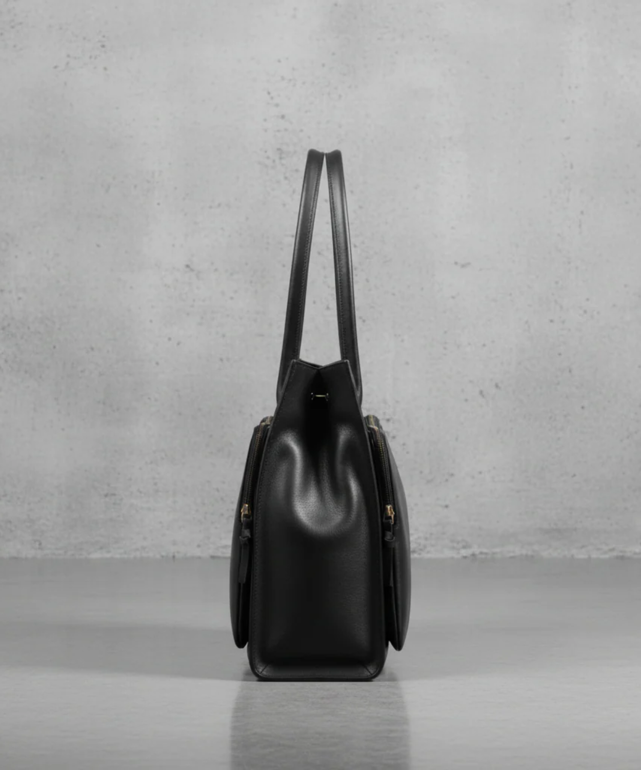Black leather handbag on a gray background