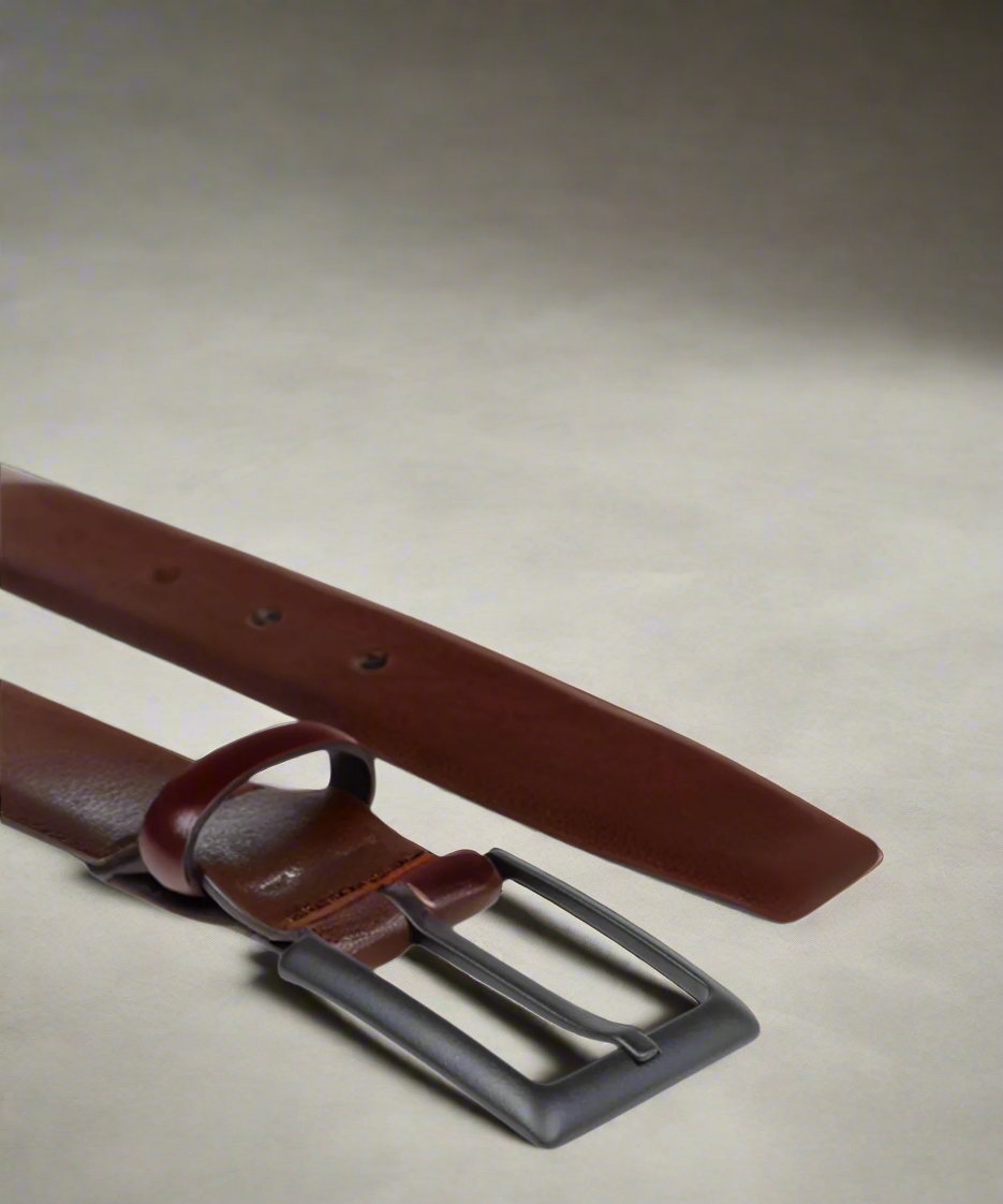 Brown Royal RepubliQ leather belt with matt black metal buckle on a light gray background