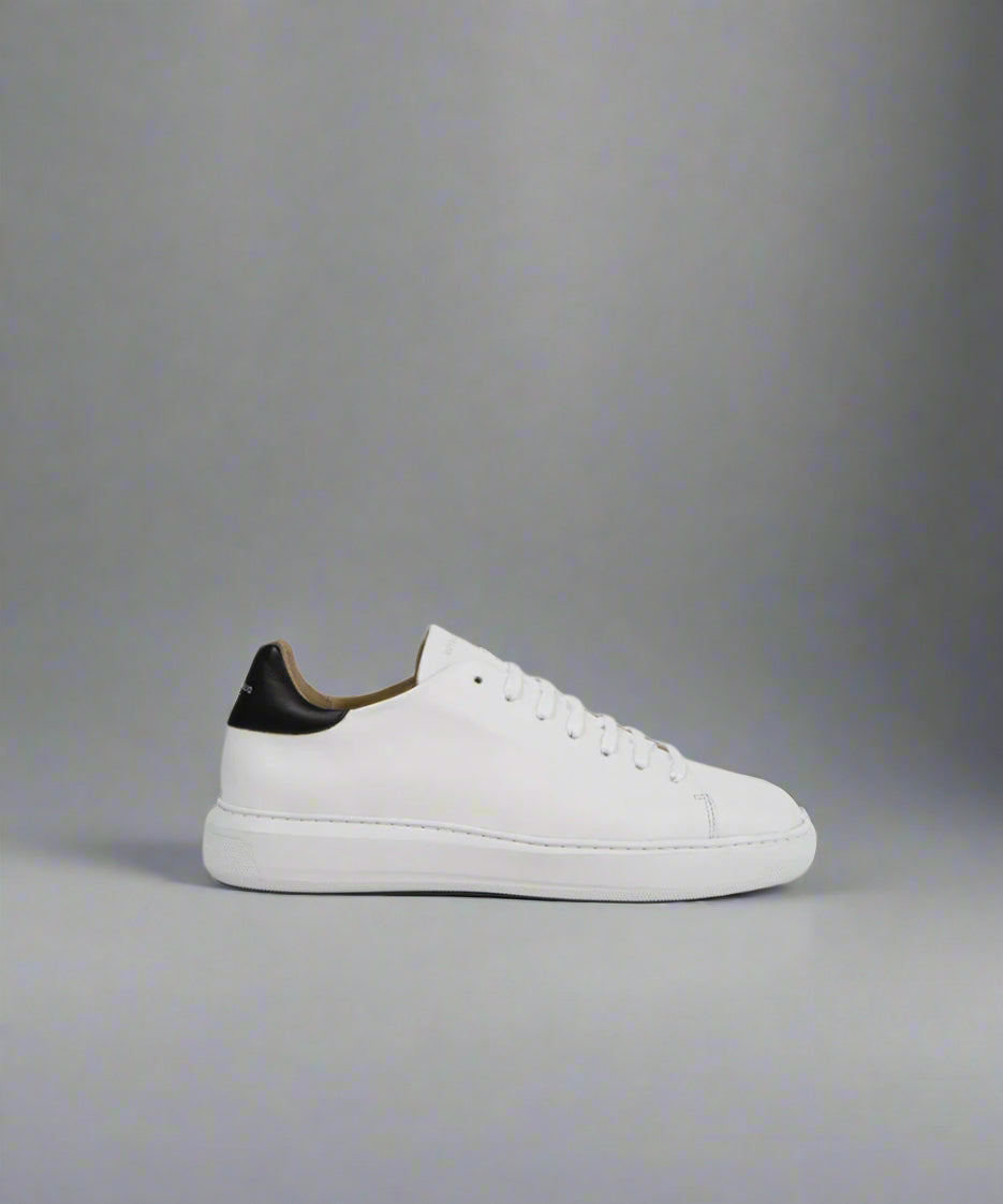 A white Cosmos sneaker with a low-top design, white laces, and a black detail at the heel on a light background.