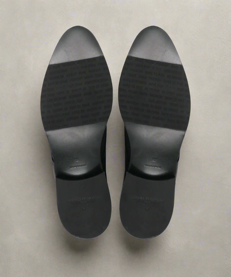 Black Royal RepubliQ shoe soles on a gray background