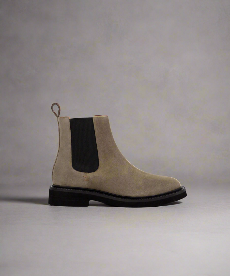A dark khaki suede Chelsea boot with elastic side panels and a low heel, crafted with sustainable materials.